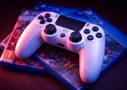 Sony PS5 DualSense controller on PlayStation 5 game cases with blue and red lighting